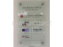 Skleněná cedule na fasádě domu se seznamem firem kotvená na nerezových distancích